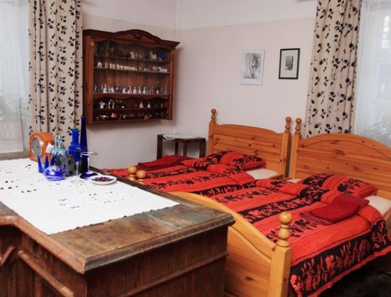 Viesu nama Baltā māja istabas iekārtojums un interjers - Numuri iekārtoti atbilsto&scaron;i 18.gs. kalpu mājas interjeram ar koka gultām un citām koka mēbelēm, austām segām un citiem vēsturiskiem priek&scaron;metiem.