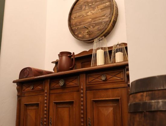 Kafejnīca Rundāles pils tuvumā, interjera skats - dekoratīva vīna muca pie sienas, senatnīga kumode.