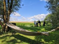 Skats uz Īslīces upes ieleju un saimniecības teritoriju ar atpūtas vietām &scaron;ūpuļtīklā zem klajas debess.